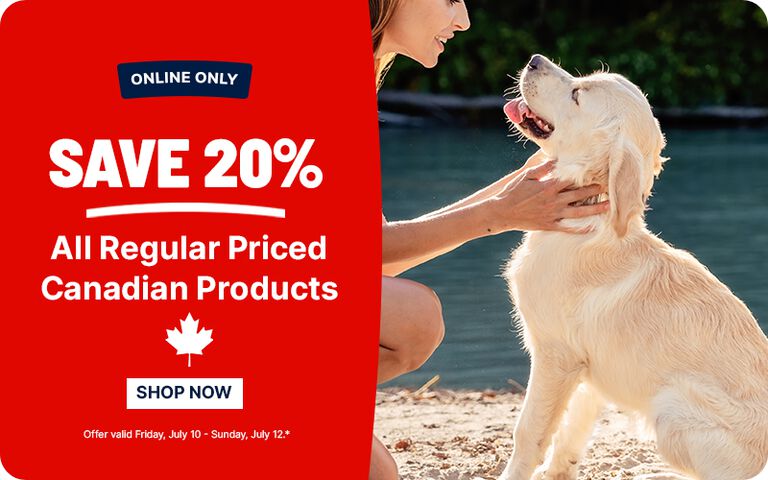 Promotional banner advertising an online-only sale: &ldquo;Save 20% All Regular Priced Canadian Products.&rdquo; A person kneels beside and pets a light-colored dog on the right, with a &ldquo;Shop Now&rdquo; button and sale dates shown on a red background.